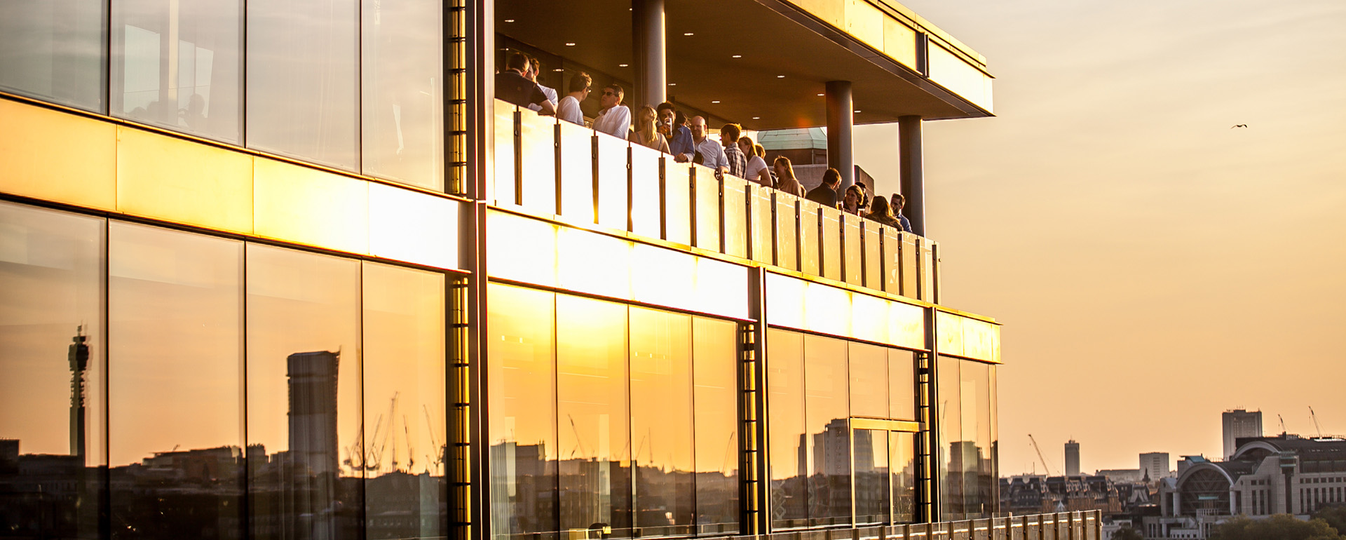 Exterior sunset shot of guests on a balcony